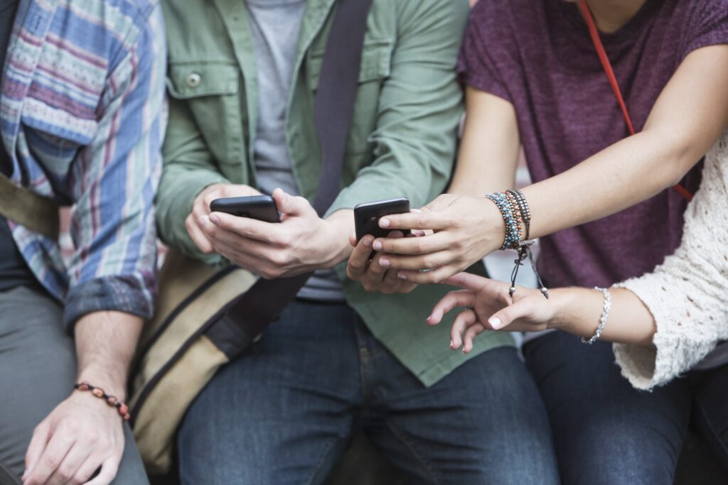 Hands of young adults with mobile phones